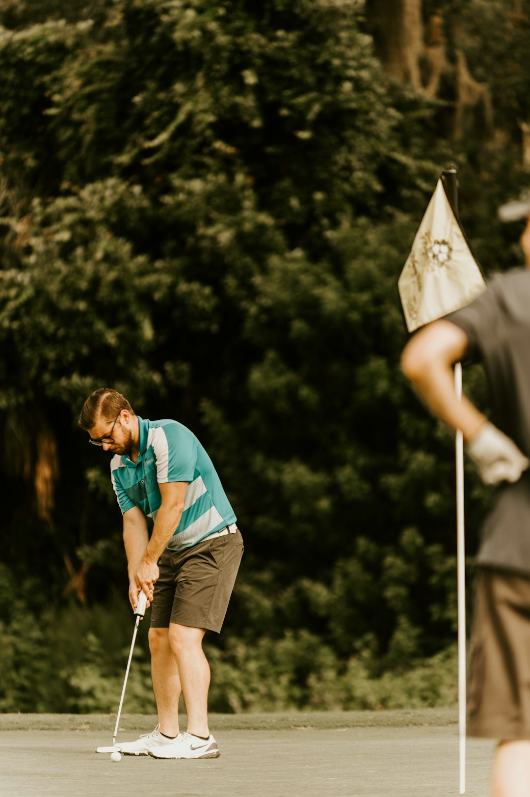 man-in-blue-t-shirt-and-brown-shorts-holding-white-and-black-flag-during-daytime-nq3mu8gmfby